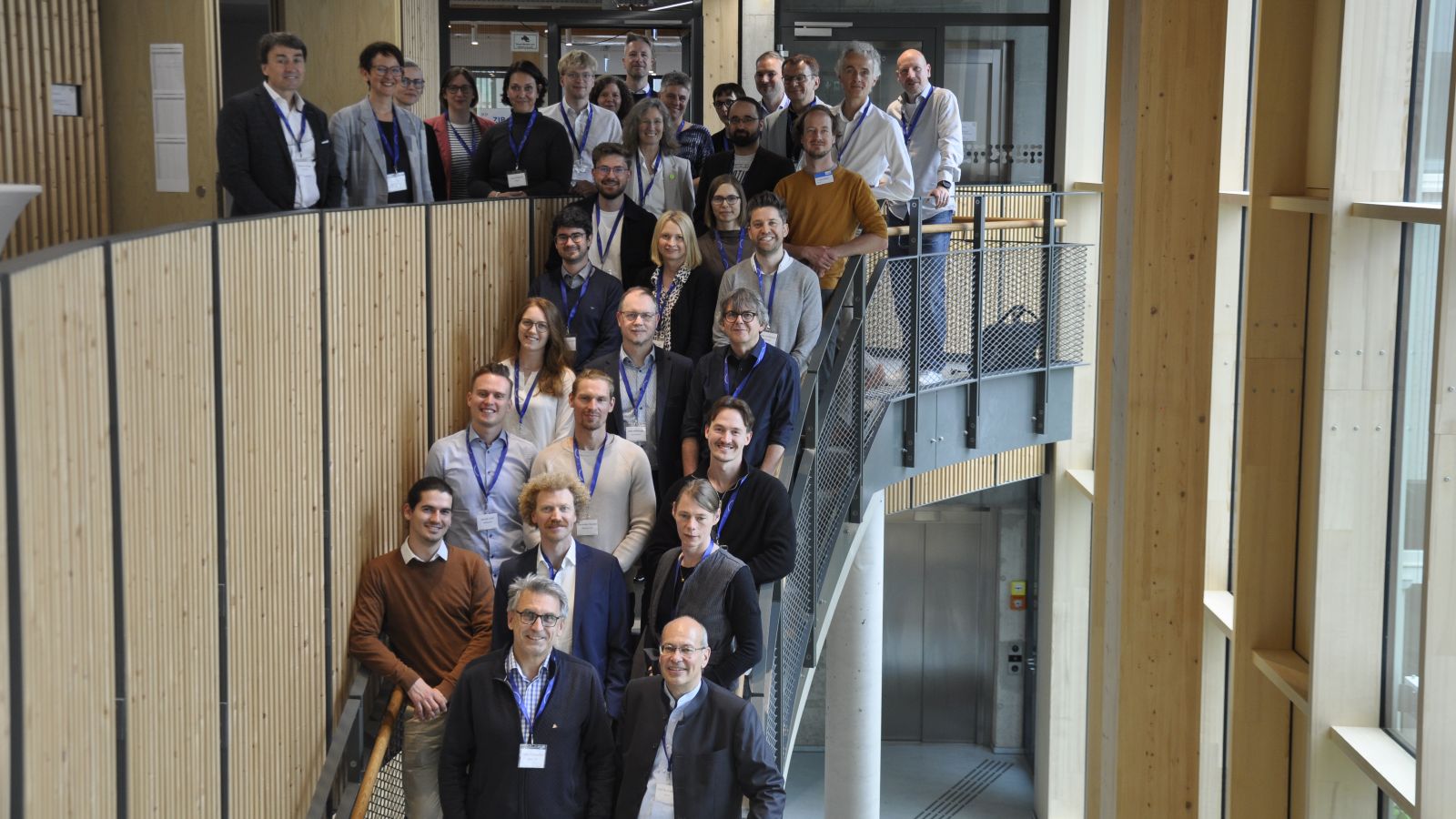 Gruppenfoto der Teilnehmenden auf einer Treppe im Gebäude